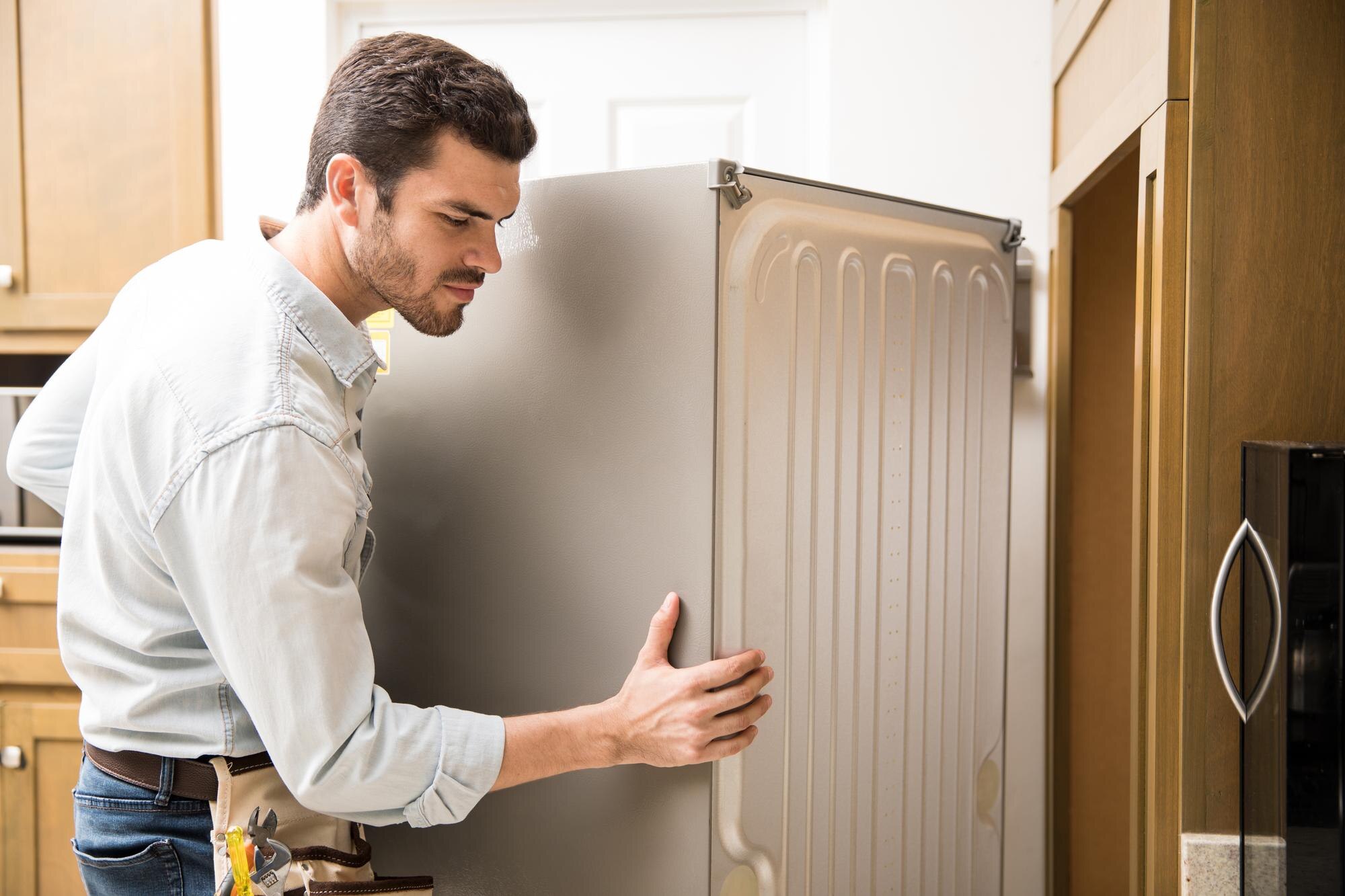 young man working as electrician exposing back fridge check repair it_662251 2712